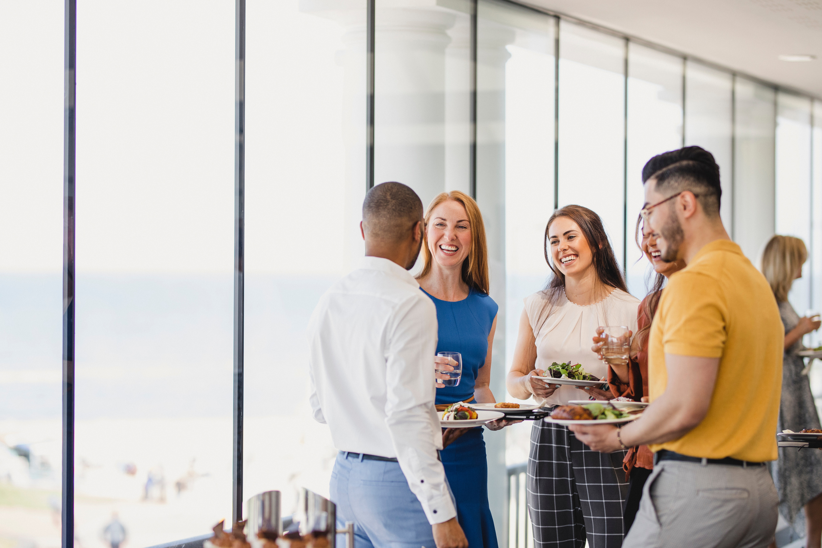 Group of cheerful colleagues enjoying lunch break at event